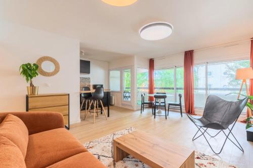 a living room with a couch and a table at Spacious apartment with balcony and parking in La Madeleine