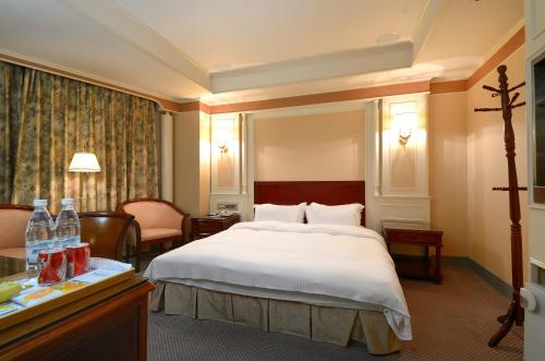 A bed or beds in a room at Duke Business Hotel