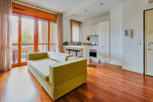 Una sala de estar con un sofá y una cocina. en Il comfort dello spazio, in un bilocale, en Milán