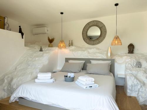 een slaapkamer met een wit bed en handdoeken bij Les Balcons du Luberon in Apt