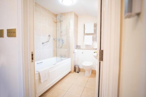 a bathroom with a tub and a toilet and a sink at The Bakehouse - central townhouse sleeps 8 people in Winchester