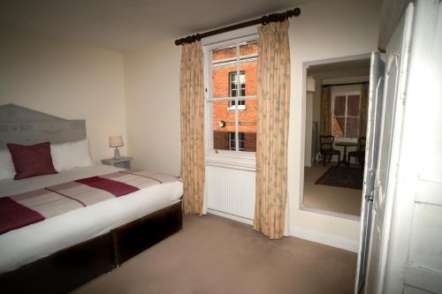 a bedroom with a bed and a window at The Bakehouse - central townhouse sleeps 8 people in Winchester