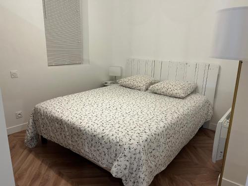 1 dormitorio con 1 cama con colcha blanca en T2 rénové - 2/4 p. Wi-Fi / Netflix, en Toulouse