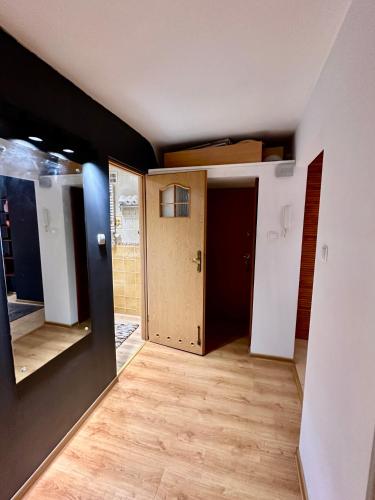 a room with a hallway with a door and wooden floors at VIEW 3 fast WiFi 1Gbs 85'TV AmazonTV HBO Disney+ in Warsaw