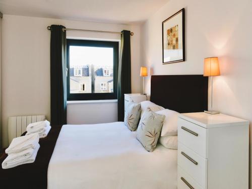 a bedroom with a white bed and a window at Your Space Apartments - Eden House in Cambridge