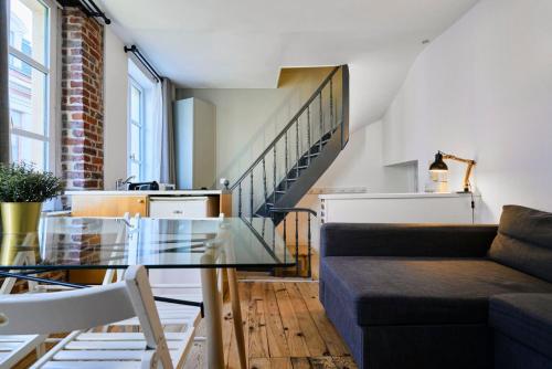 un salon avec une table en verre et un canapé dans l'établissement Grand-place & Vieux-Lille: Equipped duplex, à Lille