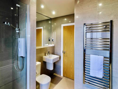 a bathroom with a toilet and a sink and a shower at Your Space Apartments - Eden House in Cambridge