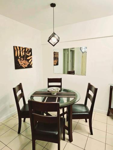 a dining room with a glass table and chairs at Camella Northpoint Bajada Near Sm lanang 2bedroom unit with balcony Davao in Davao City