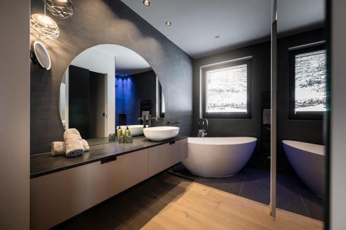 a bathroom with two sinks and a large mirror at Hotel Viertler in Avelengo