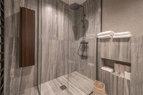 a shower with a glass door in a bathroom at Haut de gamme, Appt entier, vue sur tout Mulhouse in Mulhouse