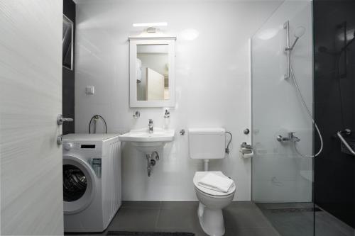 y baño con lavamanos y lavadora. en Apartment Filip Premium, en Vrsar