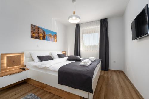 Un dormitorio con una cama grande y un televisor de pantalla plana. en Apartment Filip Premium, en Vrsar