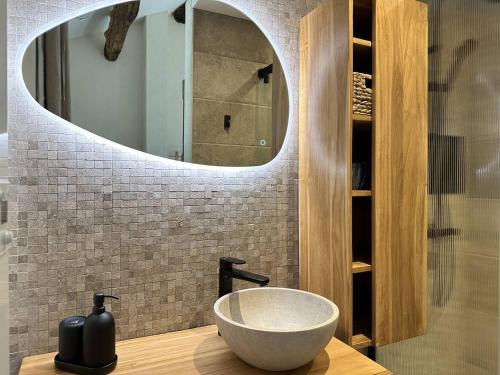 a bathroom with a bowl sink and a mirror at La Clède du PontNeuf in Valleraugue