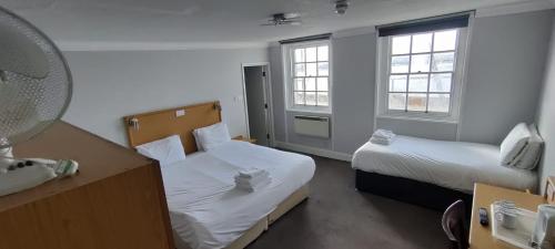 a hotel room with two beds and a mirror at Royal Hotel, Bar & Grill in Purfleet