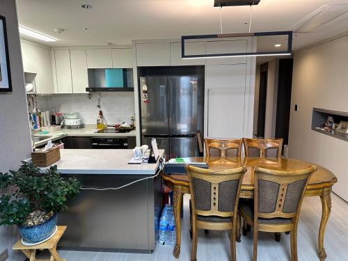 a kitchen with a wooden table and chairs at Byeollae Station ipark Suite in Namyangju