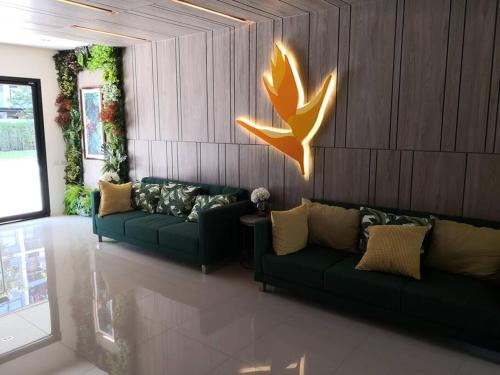 a living room with two green couches and a wall at I Condo Suvarnabhumi Airport in Bangkok