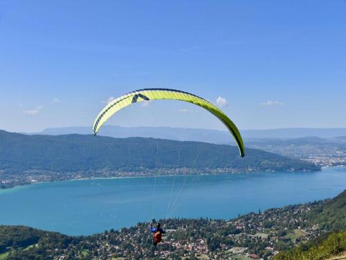 a person flying a parachute over a body of water at Campanile Annecy - Cran Gevrier in Annecy