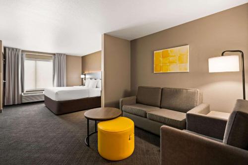 a hotel room with a couch and a bed at Comfort Suites Hudson I-94 in Hudson