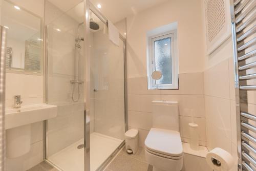 a bathroom with a shower and a toilet and a sink at Stylish, family friendly central Windermere home with wood burner in Windermere