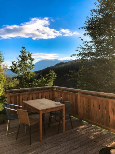 a wooden deck with a table and chairs on it at Quiet apartment with a terrace on Organic farm in Prevalje