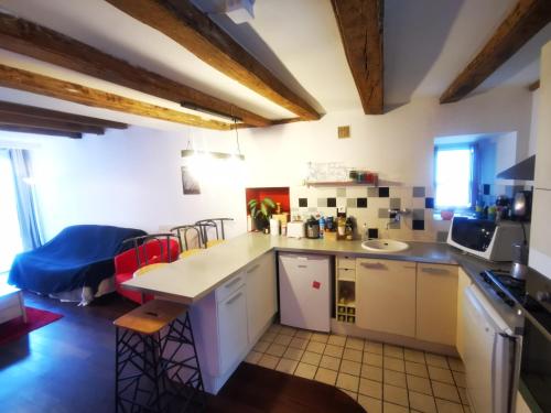 a kitchen with white cabinets and a blue couch at Trentemoult : Charmante grande maison avec vue sur Loire 105 m2 in Rezé
