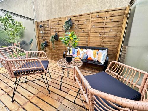 d'une terrasse avec 2 chaises en osier et une table. dans l'établissement Drouet d'Erlon duplex spacieux, terrasse au centre, à Reims