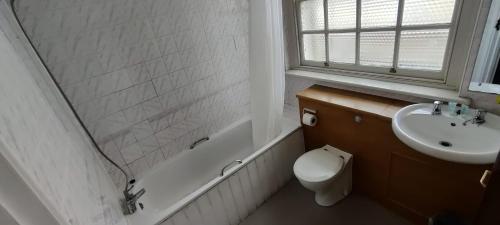 a bathroom with a sink and a toilet and a bath tub at Royal Hotel, Bar & Grill in Purfleet