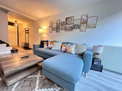 Una sala de estar con un sofá azul y una mesa. en Drouet d'Erlon duplex spacieux, terrasse au centre, en Reims