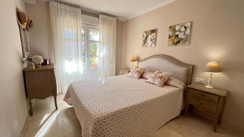 een slaapkamer met een bed en een raam bij Precioso apartamento en la playa de Jávea By El Conserje in Jávea