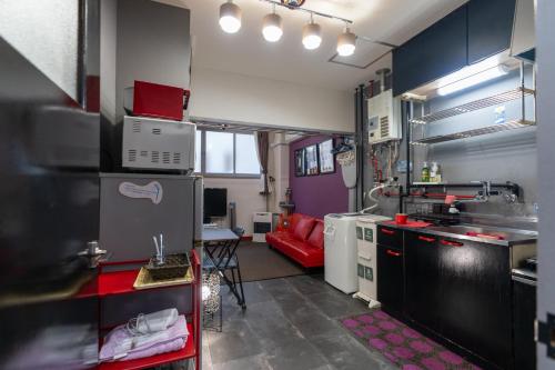uma cozinha com um sofá vermelho num quarto em Almaz Place #205 em Sapporo
