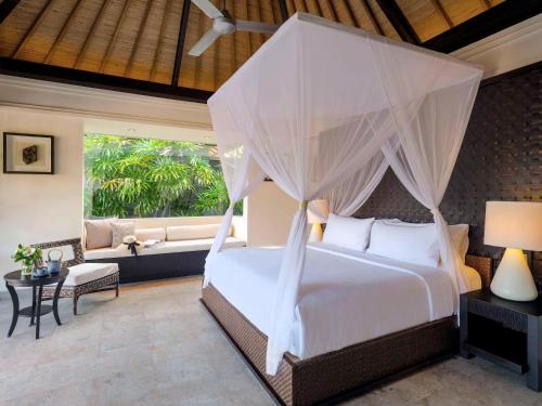 a bedroom with a white bed and a couch at Peppers Seminyak in Seminyak