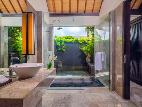 a bathroom with a bath tub and a sink at Peppers Seminyak in Seminyak