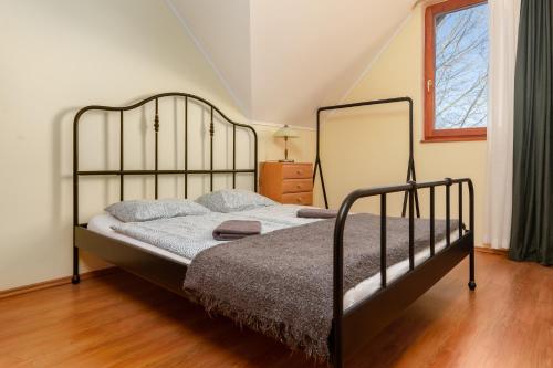 a bedroom with a bed with a metal frame at Thermal Valley Apartman - Batthyány Villapark in Zalacsány