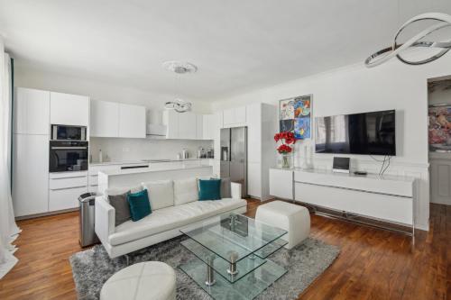 - un salon blanc avec un canapé et une table en verre dans l'établissement Élégance parisienne près des Champs-Élysées, à Paris