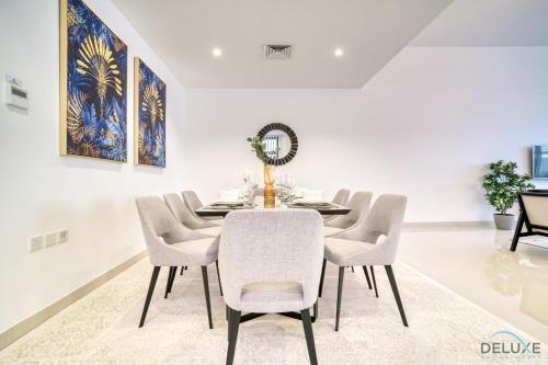 a dining room with a table and chairs at Best Deal, Classy 4BR Villa with Pool & Ocean Views by Deluxe Holiday Homes in Fujairah
