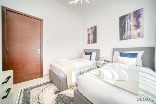 a bedroom with two beds and a door at Best Deal, Classy 4BR Villa with Pool & Ocean Views by Deluxe Holiday Homes in Fujairah