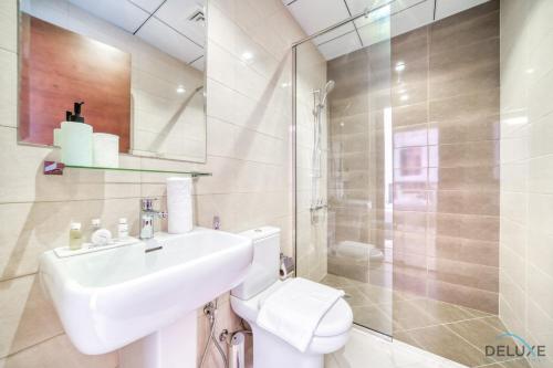 a bathroom with a toilet and a sink and a shower at Best Deal, Classy 4BR Villa with Pool & Ocean Views by Deluxe Holiday Homes in Fujairah
