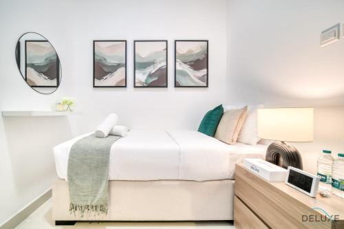 a white bedroom with a bed and a mirror at Best Deal, Classy 4BR Villa with Pool & Ocean Views by Deluxe Holiday Homes in Fujairah