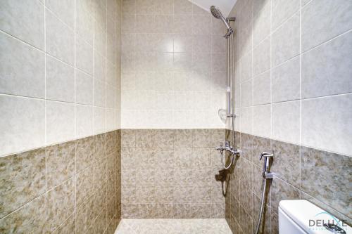 a bathroom with a shower with a toilet at Best Deal, Classy 4BR Villa with Pool & Ocean Views by Deluxe Holiday Homes in Fujairah