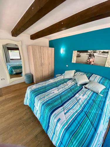 a bedroom with a large bed with a blue wall at Borgo Benedetto in Sansepolcro
