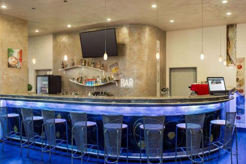a bar with blue bar stools in a room at Amedia Express Prague, Trademark Collection by Wyndham in Prague