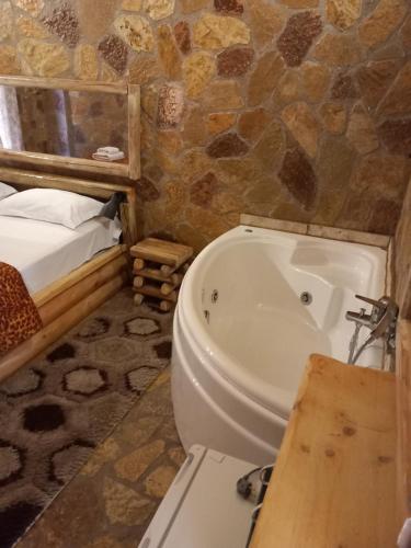 y baño con aseo, bañera y cama. en Ζachlorou Mood en Kalavrita