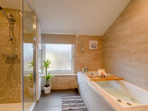 ein Bad mit einer Badewanne, einem Waschbecken und einer Dusche in der Unterkunft 1 Bed in Scarborough 90911 in Scarborough