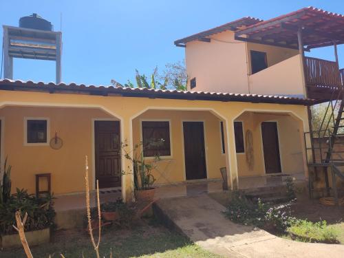 a house with yellow walls and black doors at Chalé da Selma I (Isaías) in Alto Paraíso de Goiás