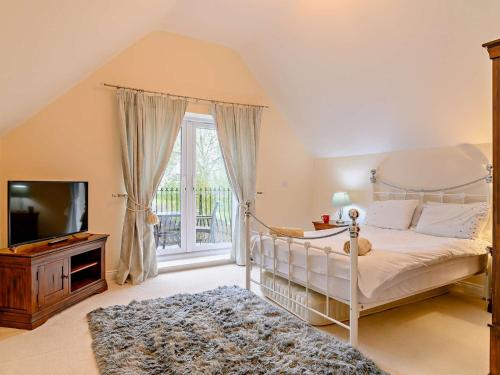 a bedroom with a canopy bed and a television at 5 Bed in Glastonbury 91657 in Meare