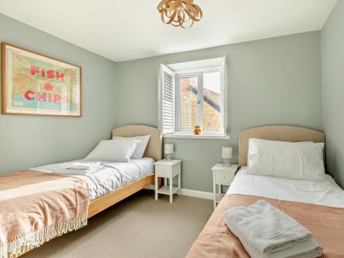 two beds sitting next to each other in a bedroom at 2 Bed in Burton Bradstock 93076 in Burton Bradstock