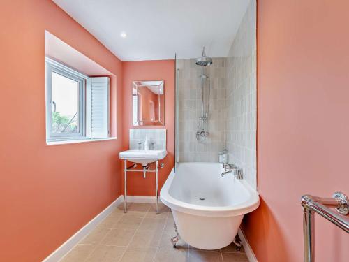 a bathroom with a white tub and a sink at 2 Bed in Burton Bradstock 93076 in Burton Bradstock