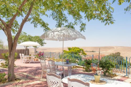 a patio with tables and chairs and an umbrella at Villa 1000 in Arad