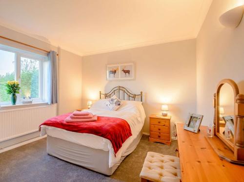 a bedroom with a bed with a red blanket and a window at 2 Bed in Whitstable 90344 in Whitstable