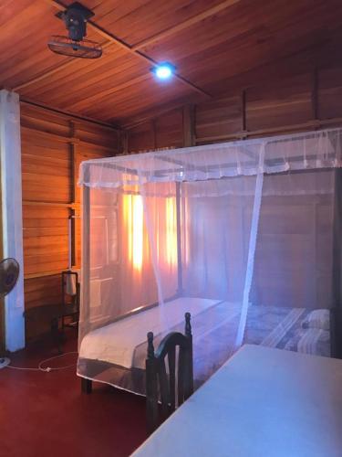 a bedroom with a bed with a mosquito net at Surf Corner in Matara